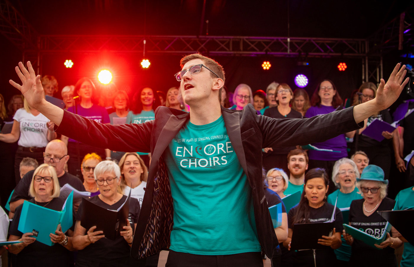 Josh Robinson, Choir Director, in front of Encore Choir