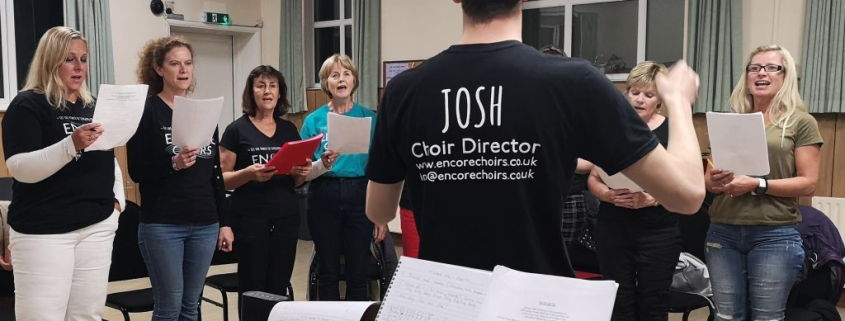 Choir rehearsal with conductor leading singers during a practice session